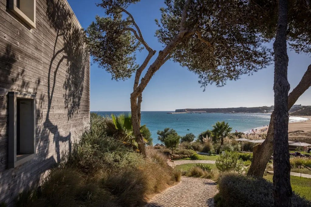 Luxurious beachfront resort with modern white buildings, azure pool, and sandy coastline of scenic coastal Portugal landscape