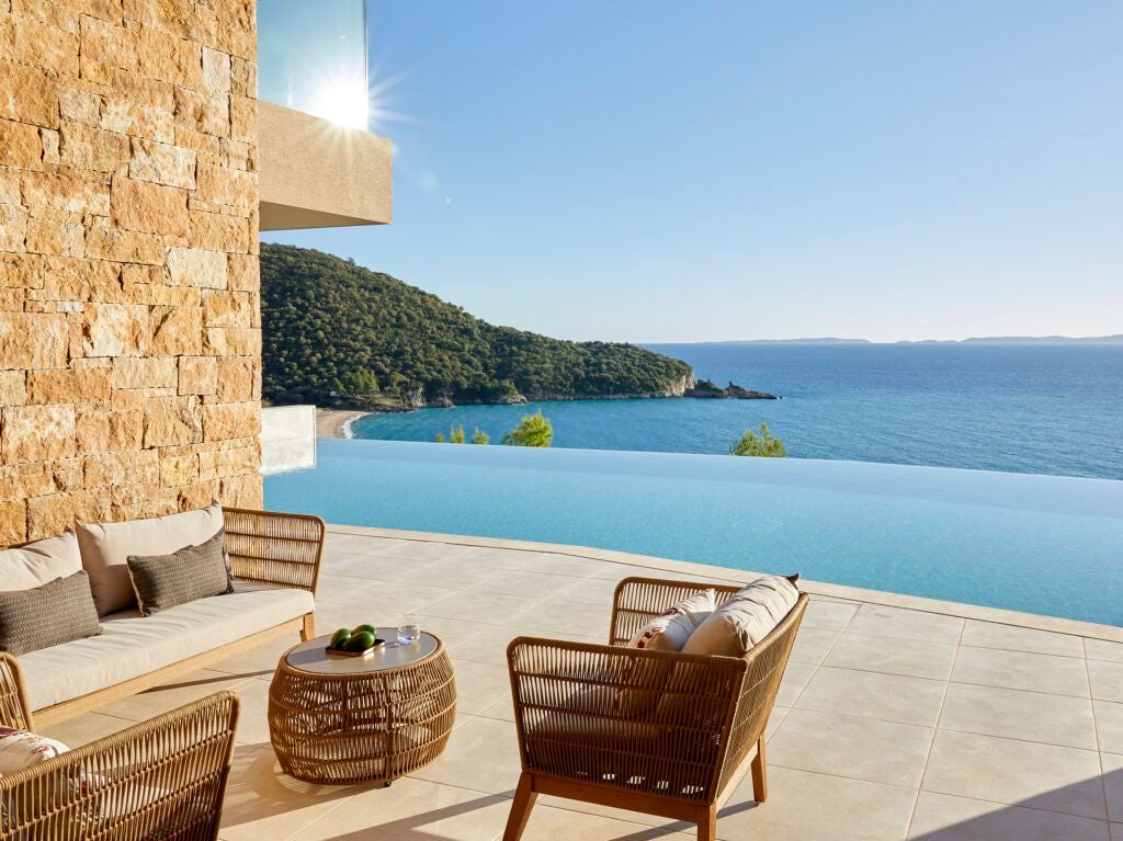 Luxurious junior suite in Greece with private infinity pool overlooking azure Aegean waters, featuring modern minimalist design and seamless indoor-outdoor living