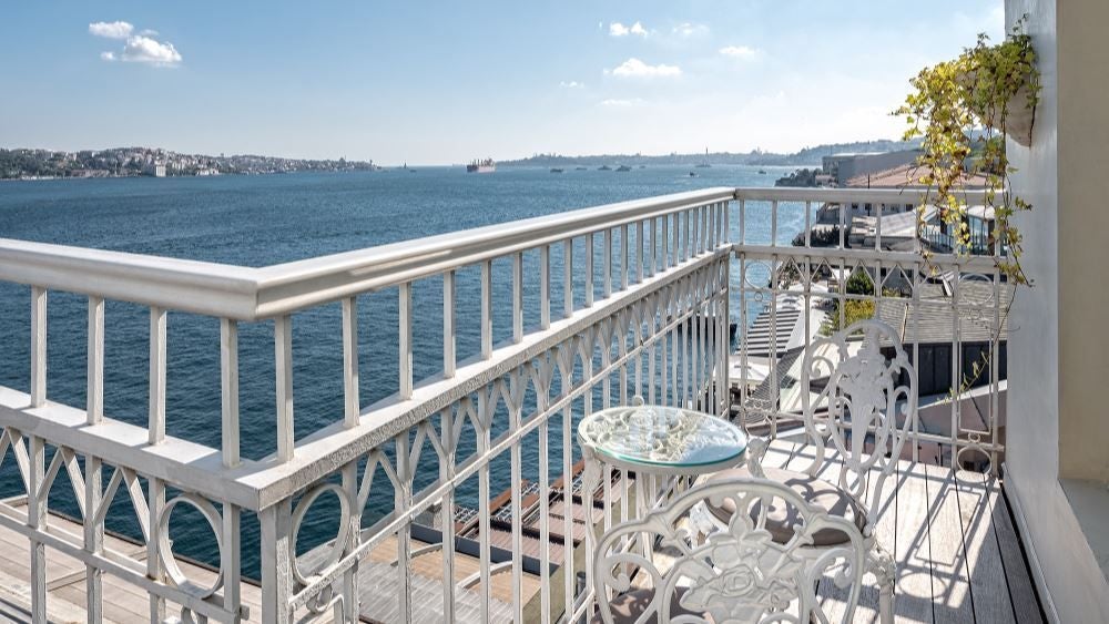 Luxurious boutique hotel with modern design overlooking Bosphorus Strait, featuring sleek white architecture and panoramic Istanbul skyline view