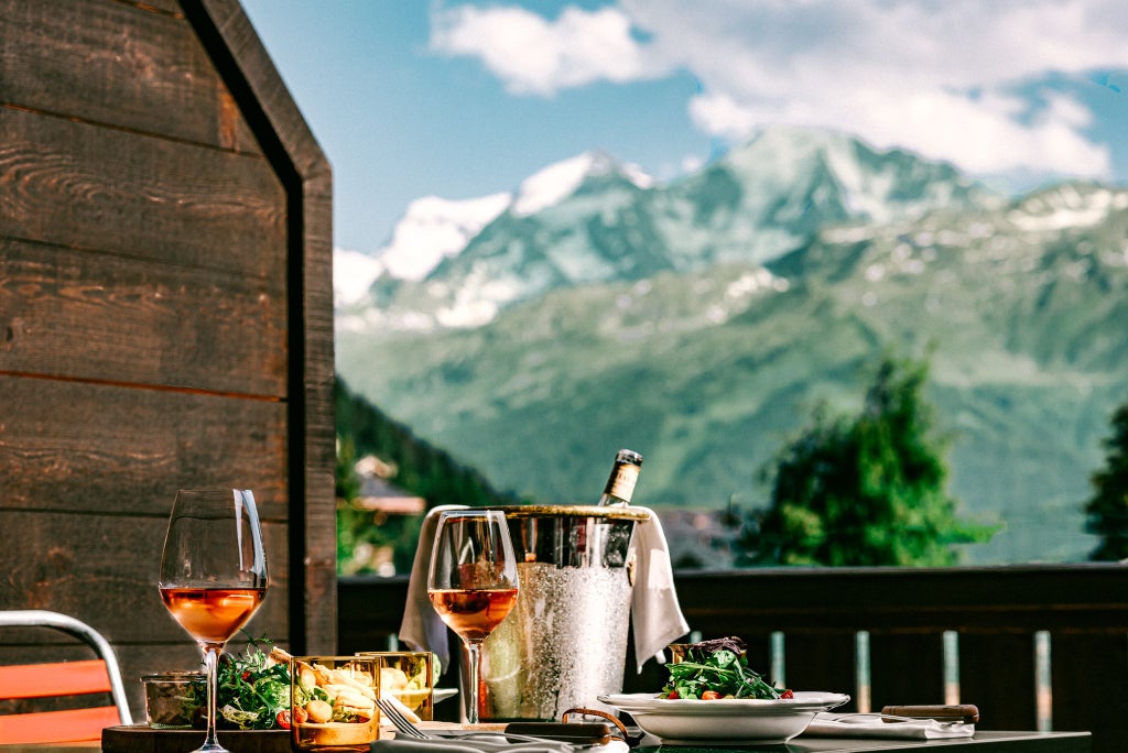 Luxurious wooden alpine chalet with panoramic snow-capped mountain views, featuring modern minimalist design and warm, inviting wooden interiors with large windows.