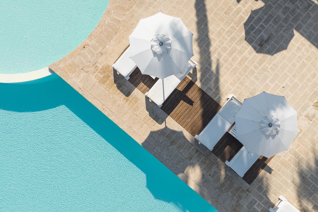 Luxurious white-walled Scenset Bianche Lifestyle Hotel nestled along the scenic Italian coastline with elegant poolside and Mediterranean design elements