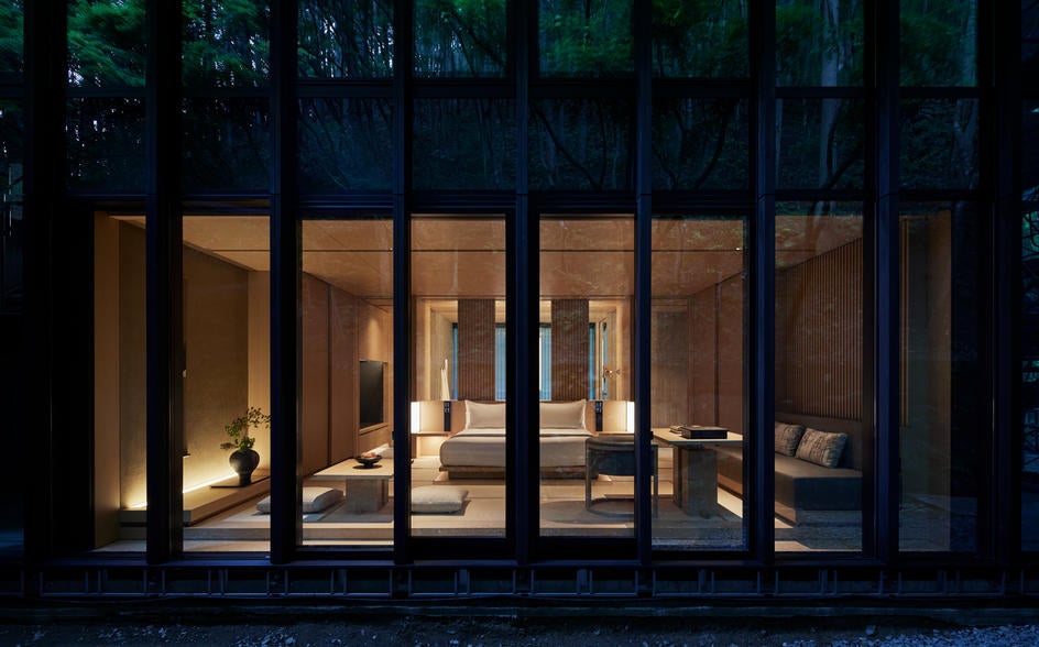 Tranquil Japanese luxury retreat nestled in a mossy forest, featuring minimalist wooden architecture and traditional lantern lighting