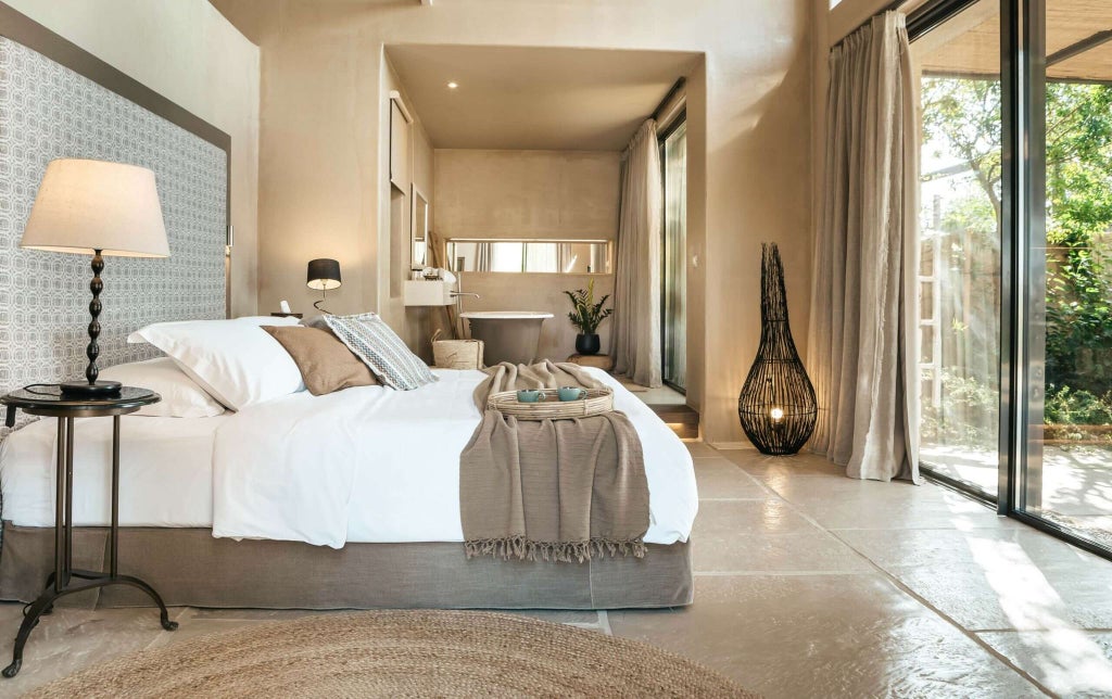 Luxurious minimalist suite with soft white linens, wooden floors, panoramic sea view, and elegant contemporary design in Kefalonian boutique resort