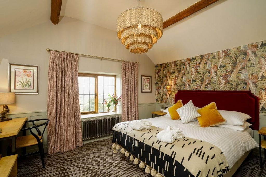 Elegant superior room with plush bedding, rich wood furnishings, and soft neutral tones at a charming countryside inn in the United Kingdom.