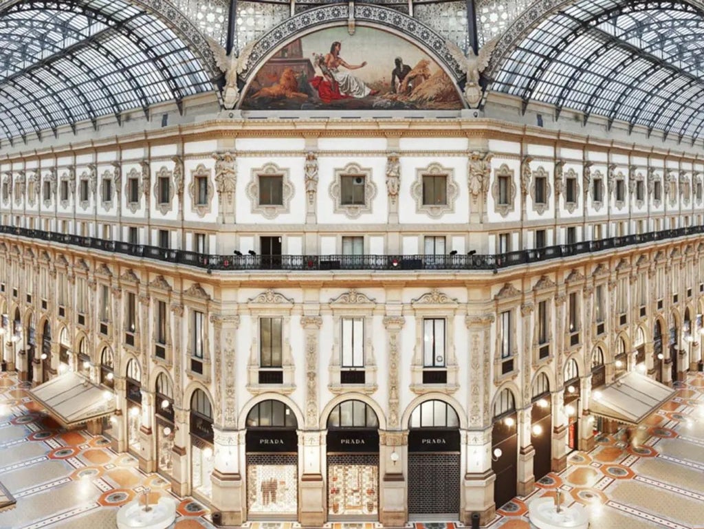 Luxurious marble lobby of modern Italian hotel with designer furniture, dramatic chandeliers, and elegant architectural details in Milan's city center.