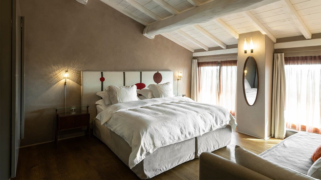 Elegant rustic Italian boutique hotel room with white linens, wooden floors, soft natural light, and minimalist design overlooking scenic countryside landscape