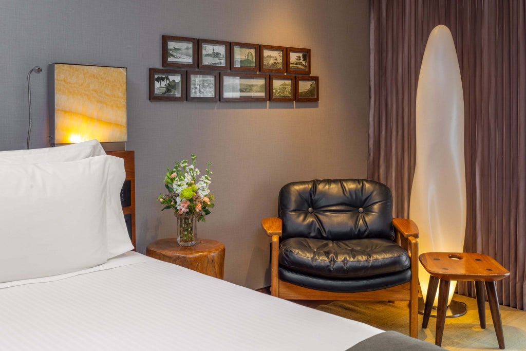 Elegant Fasano Rio de Janeiro hotel room with contemporary Brazilian design, plush bedding, and a serene courtyard view bathed in soft, natural light.