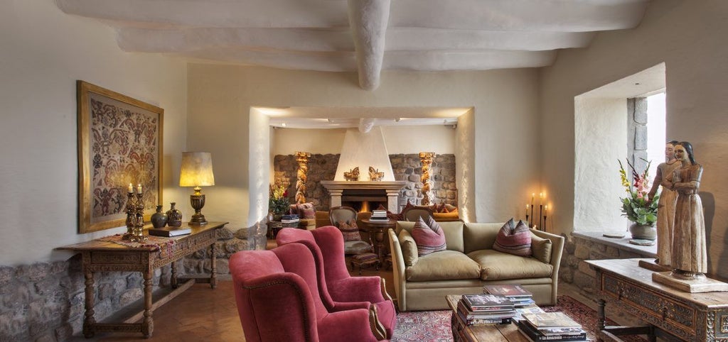 Historic luxury hotel in Cusco featuring colonial Spanish architecture with stone archways, ornate wooden balconies and manicured courtyard