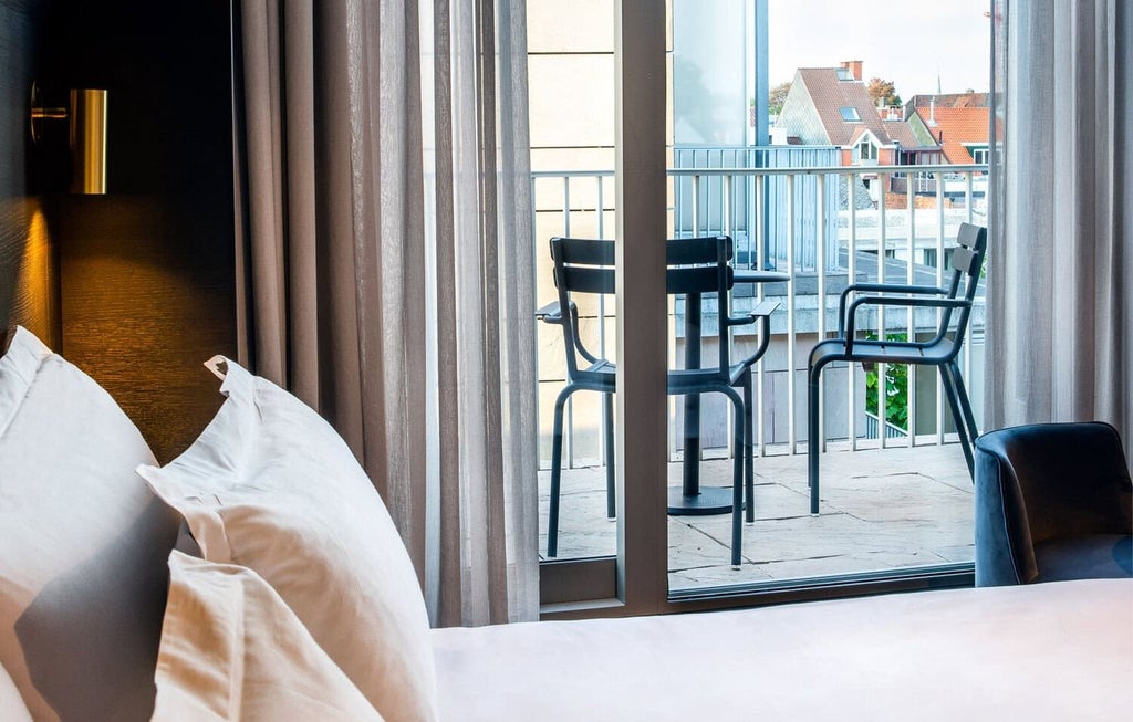 Elegant balcony of luxury hotel room at Pillows Grand Boutique Hotel Reylof, overlooking Belgian cityscape with plush white bedding and modern decor