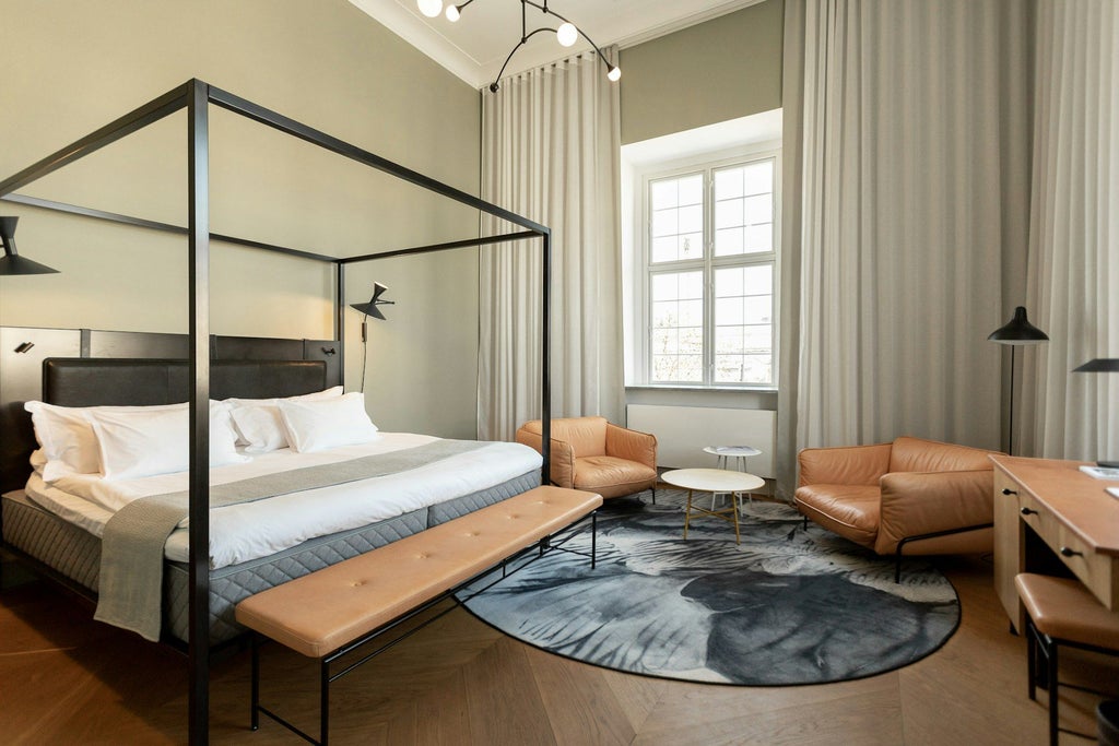 Elegant Scandinavian-style junior suite with contemporary design, plush king bed, minimalist furniture, and soft neutral color palette in luxury Danish hotel room