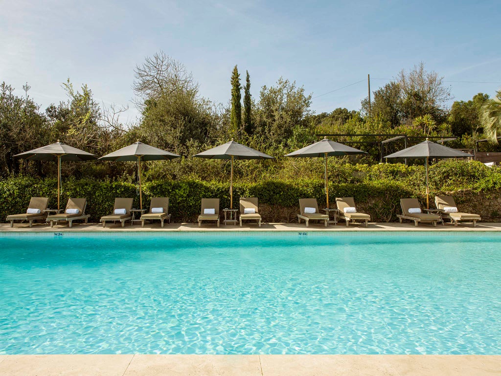 Stone villa and luxury spa resort with terracotta roof, surrounded by manicured gardens and cypress trees in rural Costa Brava