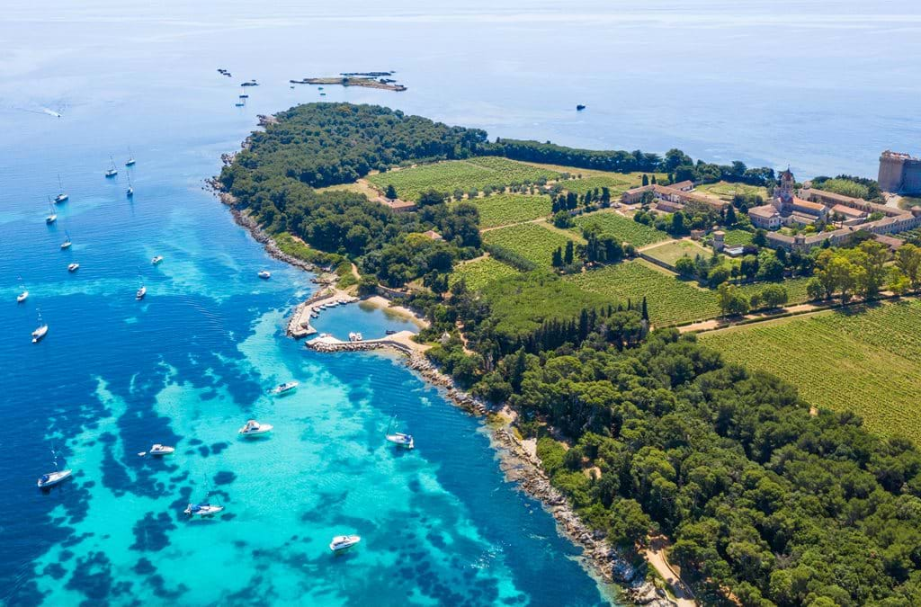 Luxurious seaside hotel with grand white Mediterranean architecture, infinity pool overlooking the French Riviera's azure waters