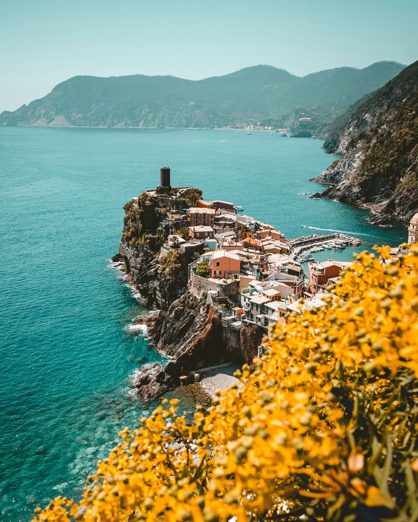 Colorful hillside houses in Portofino's harbor, with luxury yachts moored at sunset against the backdrop of the Italian Riviera