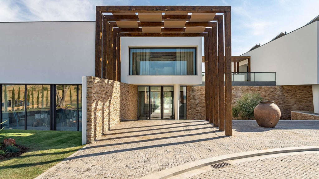 Serene infinity pool overlooking Alentejo countryside at sunset, with modern lounge chairs and elegant stone architecture of Octant Evora