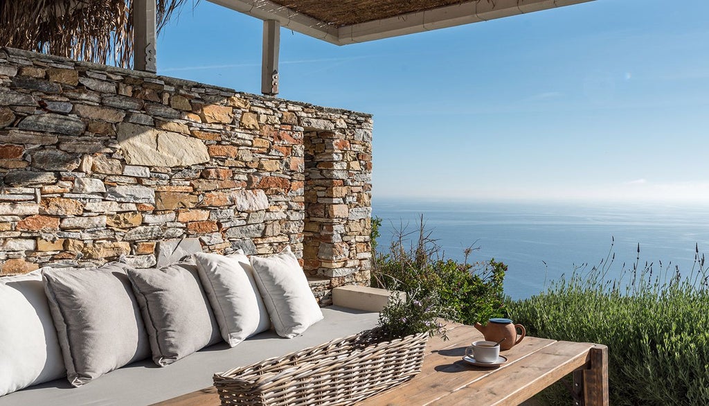 Minimalist white Greek hotel room with panoramic Aegean Sea view, sleek contemporary design, and private balcony overlooking scenic coastal landscape at sunset