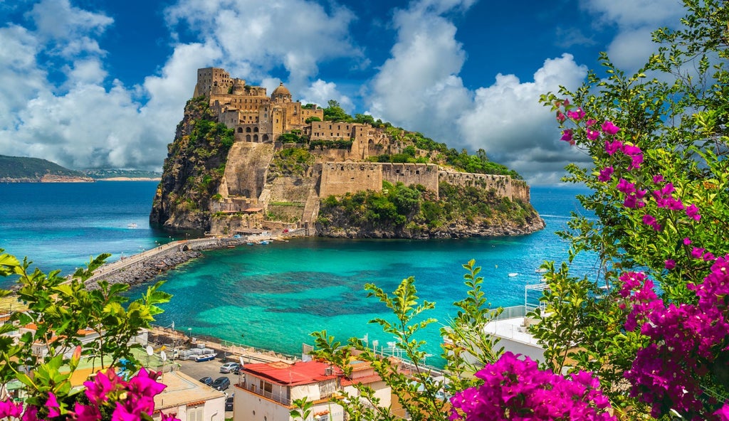 Elegant cliffside hotel overlooking Mediterranean Sea, featuring infinity pool, manicured gardens and private beach access at sunset