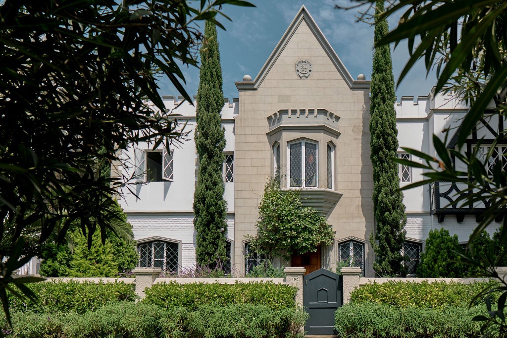 Elegant Peruvian colonial mansion hotel with minimalist design, white walls, lush greenery, and sophisticated urban luxury aesthetic in Lima's Barranco district