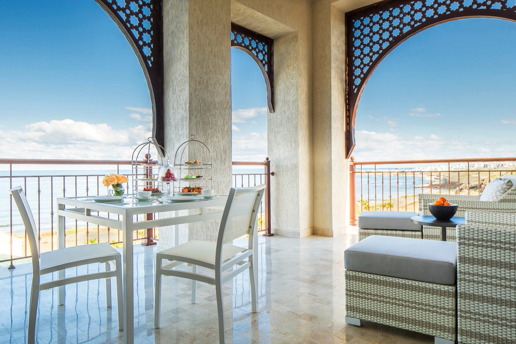 Elegant beachfront Four Seasons hotel in Tunis with white Moorish architecture, palm trees, and infinity pools overlooking Mediterranean Sea