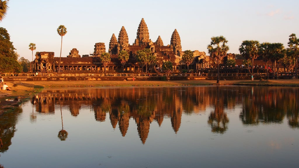 Ancient stone temple ruins of Angkor Thom, expansive 12th-century Cambodian archaeological site with intricate carved faces and lush tropical vegetation