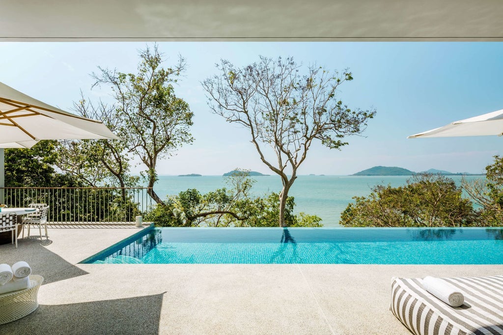 Luxurious contemporary hotel overlooking Phang Nga Bay, featuring minimalist Thai-inspired architecture with crisp white design and panoramic azure ocean views