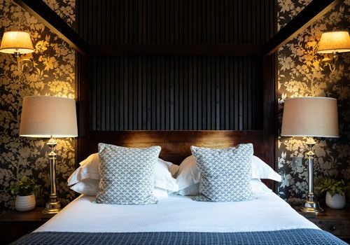 Luxurious boutique hotel room with plush white bedding, contemporary design, and elegant neutral tones at Yorebridge House in scenic UK countryside.