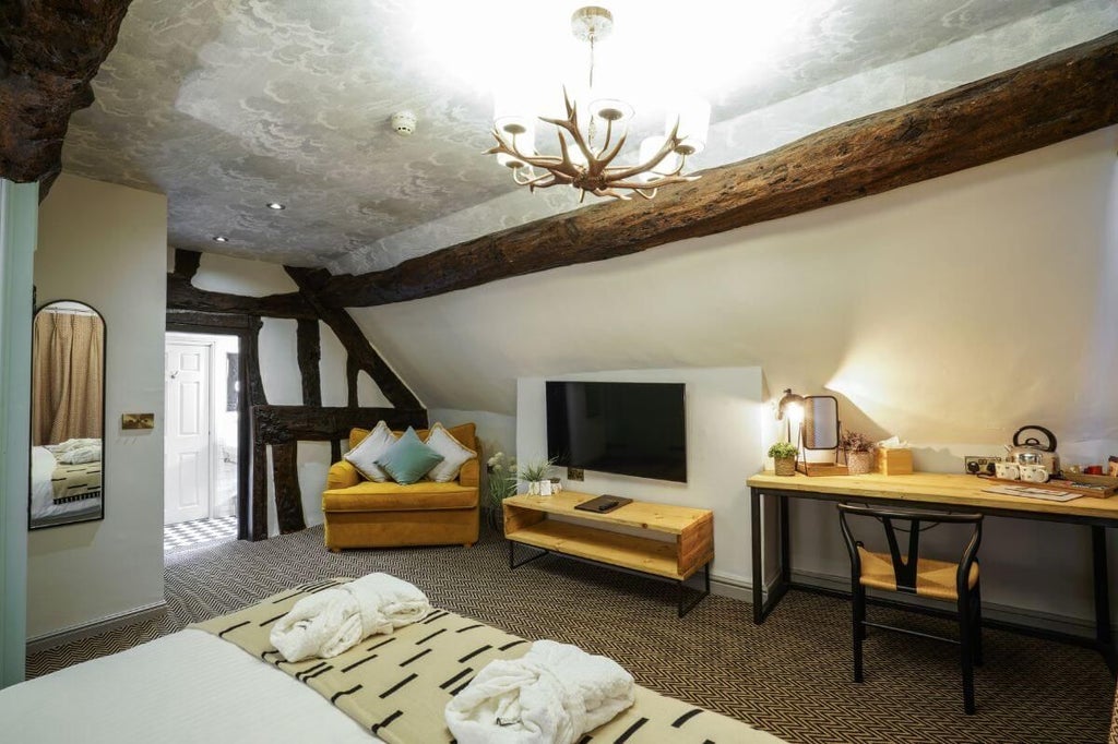 Elegant executive room at scenset Inn, featuring plush bedding, rich wooden furnishings, soft ambient lighting, and refined traditional British decor with countryside charm