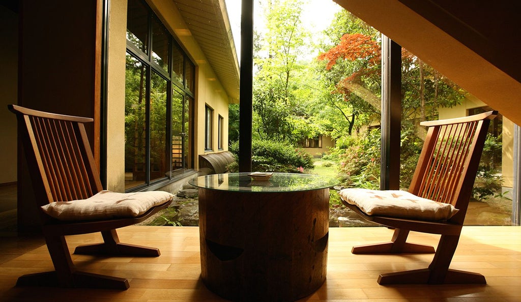 Elegant traditional Japanese ryokan with wooden architecture, tranquil garden, soft natural lighting, and minimalist design overlooking serene mountain landscape