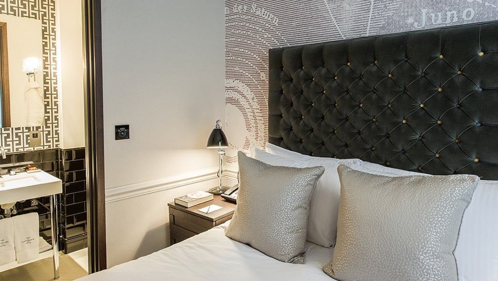 Elegant superior hotel room with plush white bedding, contemporary design, and soft neutral colors at scenset luxury boutique accommodation in United Kingdom