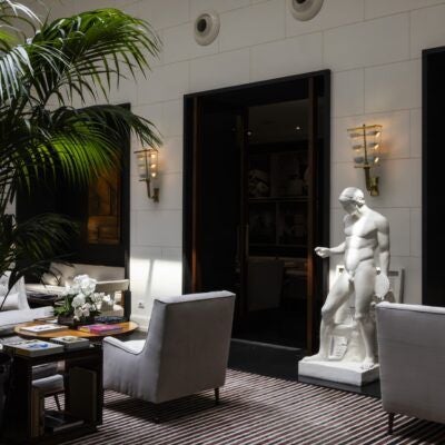 Elegant white-draped dining area at J.K. Place Roma, with classic Italian design, marble tables, and chic minimalist decor overlooking a sunlit terrace