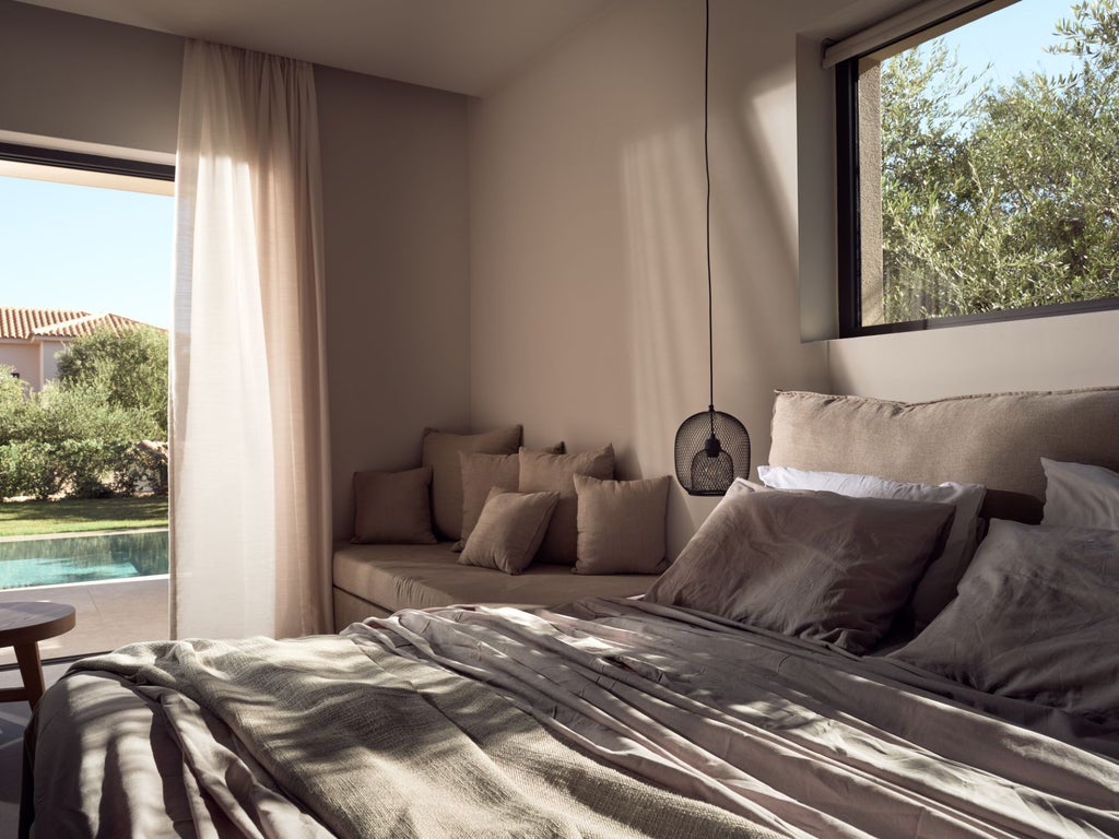 Luxurious white villa bedroom with panoramic Aegean Sea view, minimalist design, private balcony, and elegant blue and white color palette characteristic of Greek island architecture