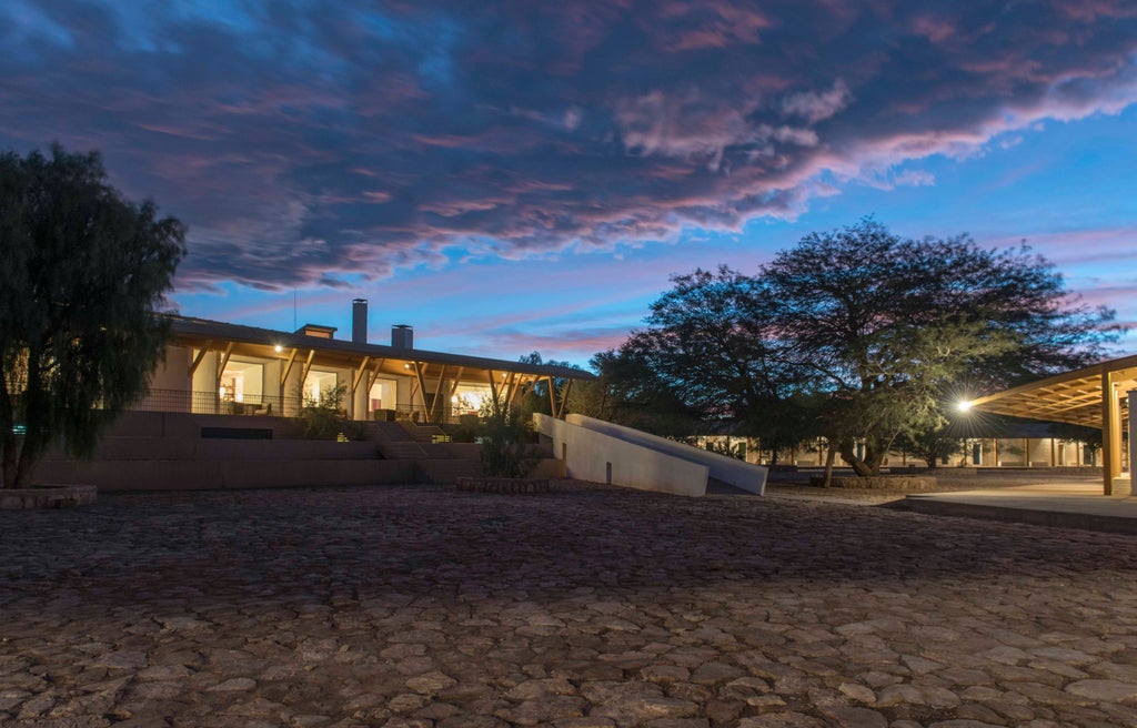 Contemporary desert lodge with clean-lined wooden architecture and pool terrace surrounded by volcanic peaks in Chile's Atacama Desert