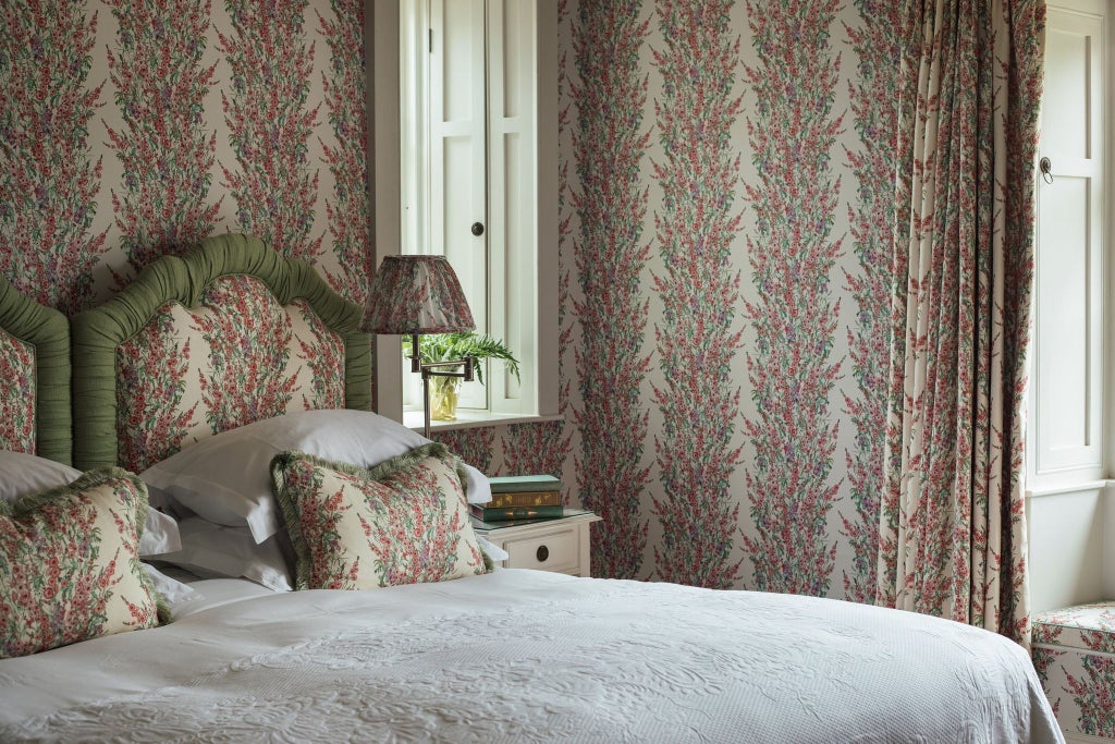 Luxurious hotel bedroom with soft sage green walls, crisp white linens, elegant wooden furniture, and refined minimalist design in UK boutique hotel