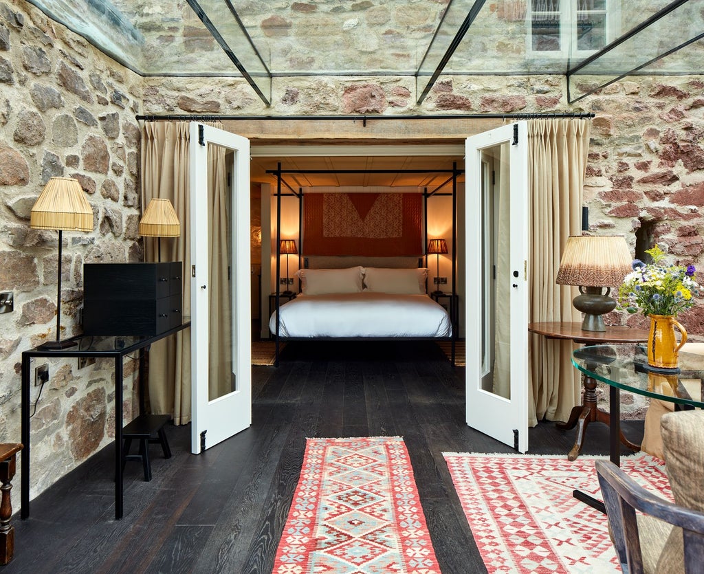 Elegant wooden-paneled bedroom with plush white linens, rustic oak furniture, and soft natural light filtering through countryside-style windows at Grove of Narberth.