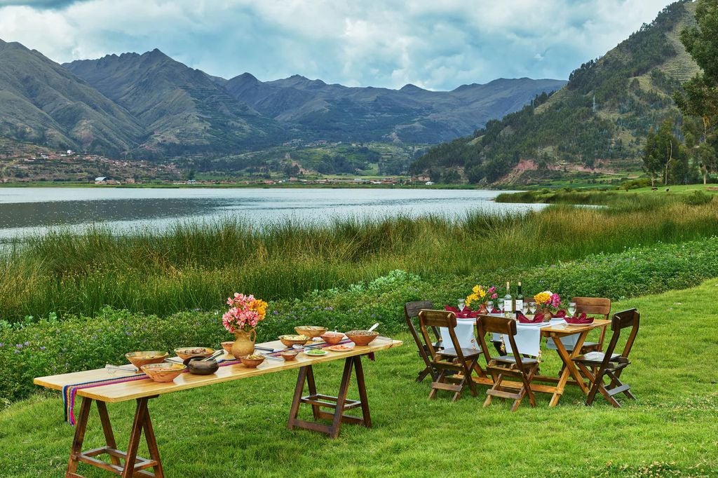 Five-star mountain resort with stone and glass architecture nestled in Sacred Valley, reflecting in serene pool at golden hour