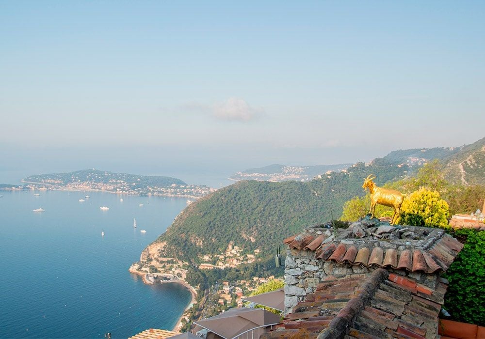 Luxury clifftop hotel overlooking the French Riviera, with terraced gardens and infinity pool merging into Mediterranean Sea views