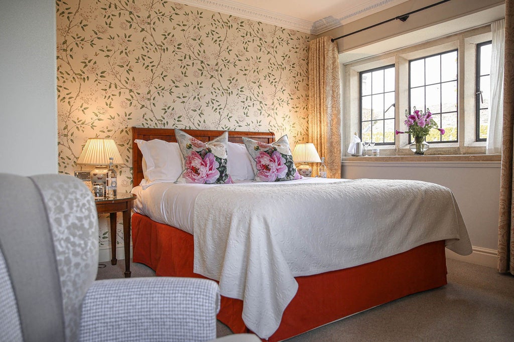 Elegant classic hotel room with plush king bed, soft cream and beige color palette, traditional furnishings, and refined Country House style decor at luxury UK spa hotel