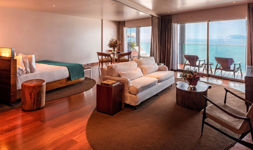 Elegant ocean front suite at Fasano Rio, featuring panoramic views of Ipanema Beach, modern minimalist decor with sleek furniture and floor-to-ceiling windows