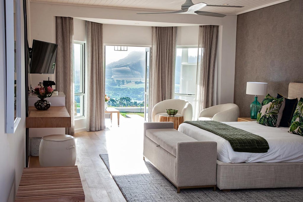 Elegant boutique hotel nestled in South African wine country with panoramic mountain views, infinity pool and manicured gardens