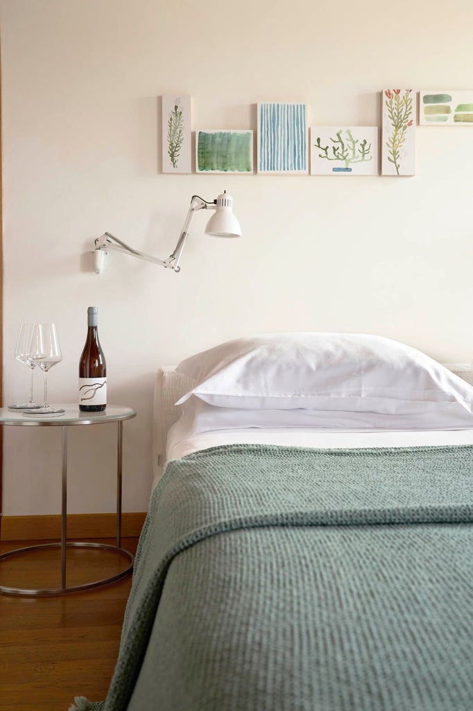 Elegant comfort room with herringbone wood floors, antique brass fixtures, and arched windows overlooking Venetian vineyards