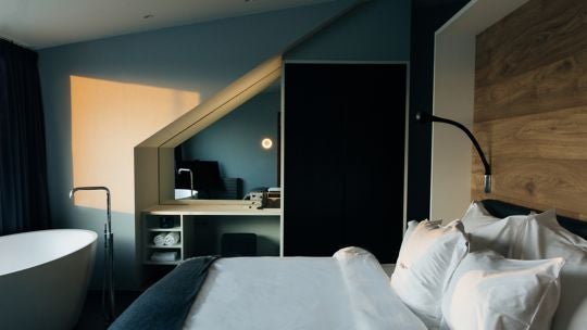 Luxurious panoramic suite with floor-to-ceiling windows overlooking Icelandic urban landscape, featuring modern minimalist design and sleek Nordic furnishings