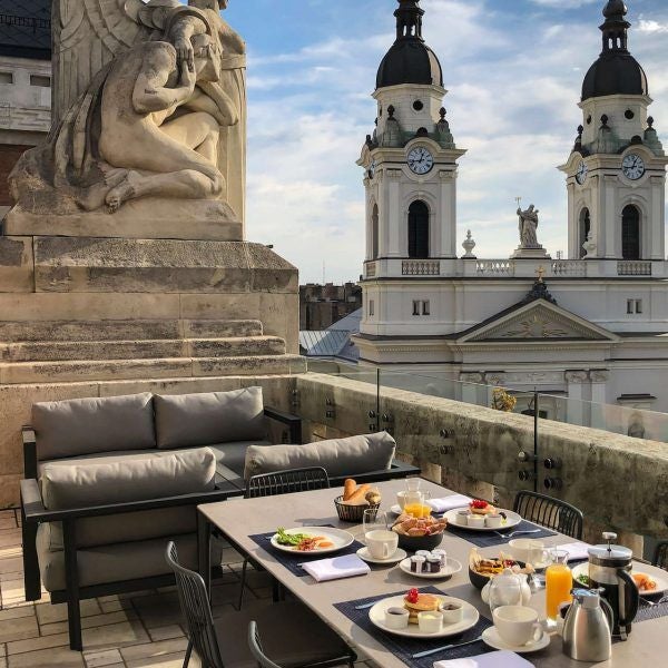 Luxurious hotel interior with modern design, featuring sleek furnishings, warm lighting, and elegant spa area overlooking scenic Hungarian landscape