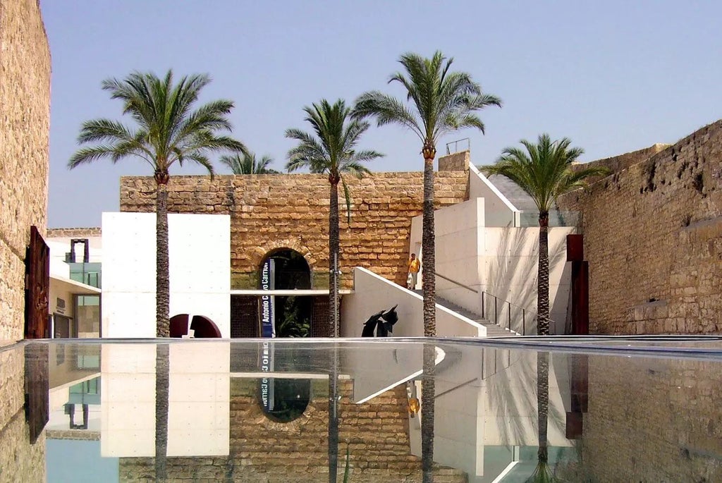 Elegant stone facade of historic Scenset Convent converted to luxury hotel, featuring arched windows and traditional Mediterranean architectural details in soft sunlight