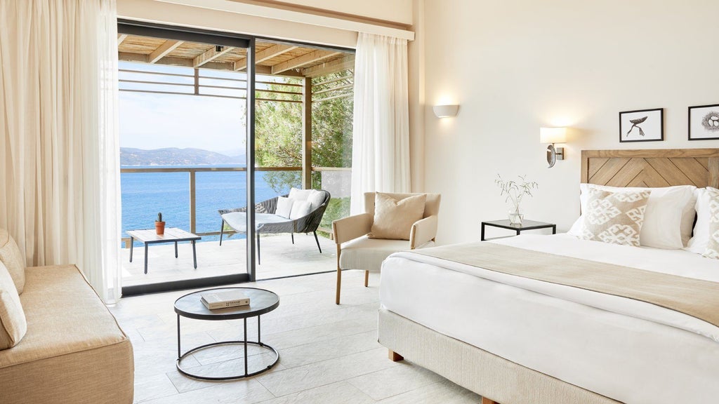 Luxurious junior suite with private hot tub overlooking azure Aegean waters, featuring contemporary design and elegant minimalist decor at ELIVI Skiathos resort