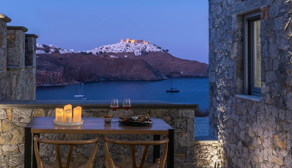 Elegant white-washed luxury suites with blue-domed roofs overlooking the azure Aegean Sea, capturing the pristine charm of Greek island architecture in Stampalia