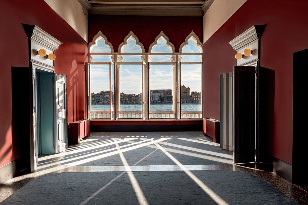 Elegant Venetian-style luxury hotel with ornate marble facade, historic architectural details, and warm golden lighting at dusk