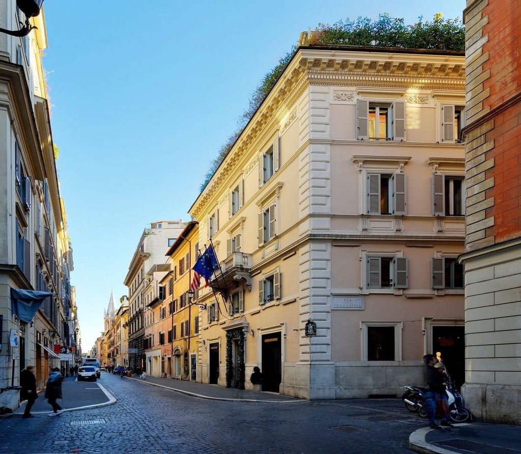 Elegant marble facade of Babuino 181 boutique hotel in Rome, with wrought iron balconies and classic Italian architectural details