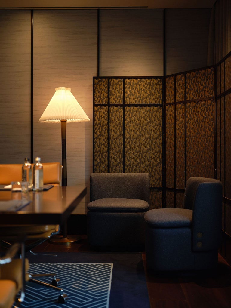 Elegant modern hotel lobby with sleek Japanese-inspired design, featuring minimalist furniture, warm wood tones, and soft lighting at Luxury Hotel in central London.