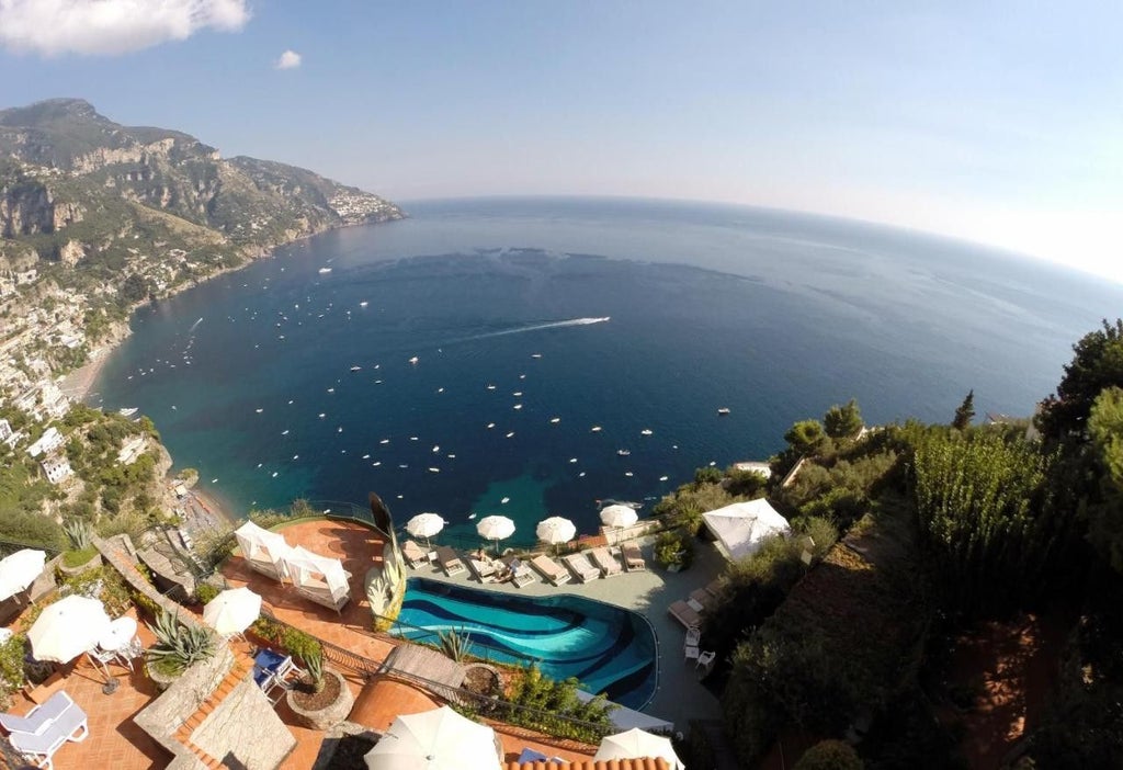 Luxurious resort nestled into cliffside in Positano, Italy with cascading terraces, infinity pools and panoramic views of Amalfi Coast