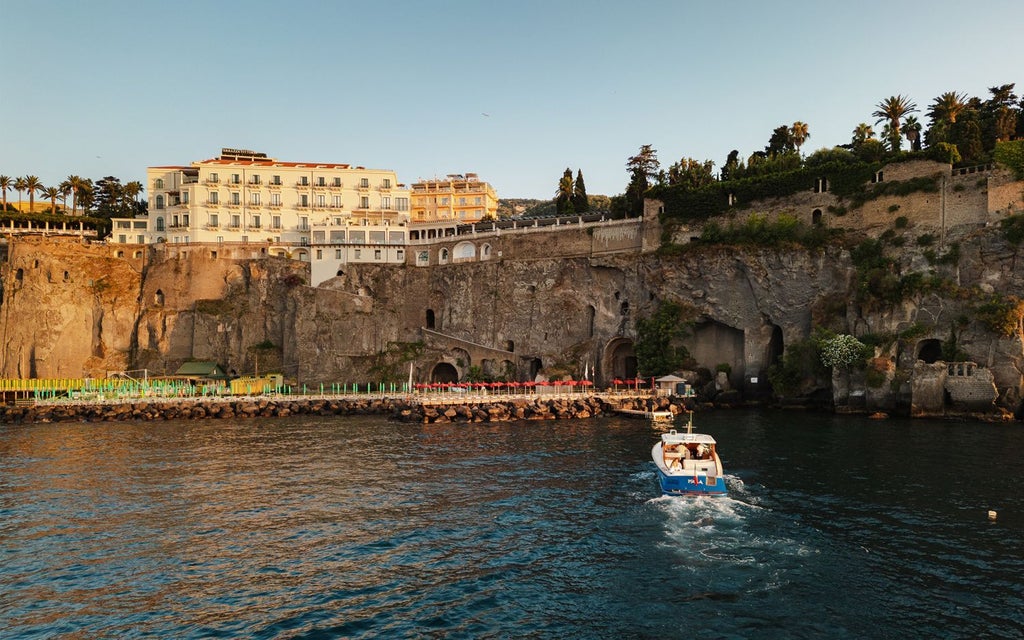 Elegant limestone terrace of Bellevue Syrene hotel overlooking azure Sorrentine coastline with luxurious Mediterranean architecture and cascading bougainvillea