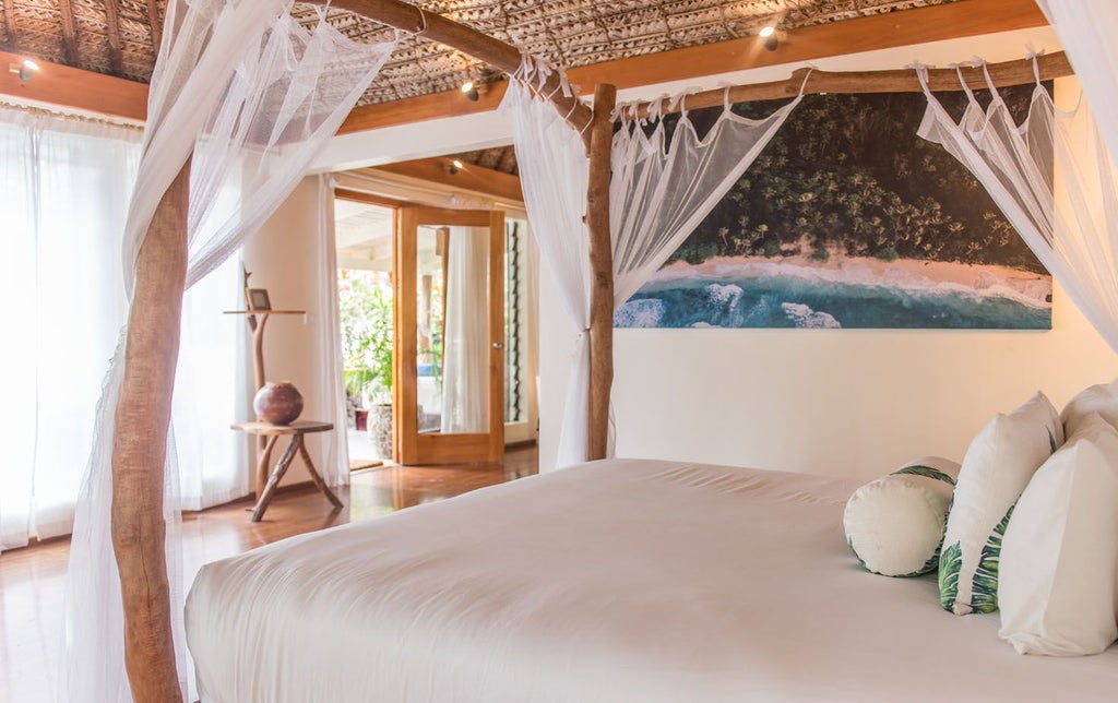 Spacious Fijian beachfront villa with wooden deck, turquoise ocean view, luxurious king bed, and elegant tropical interior design